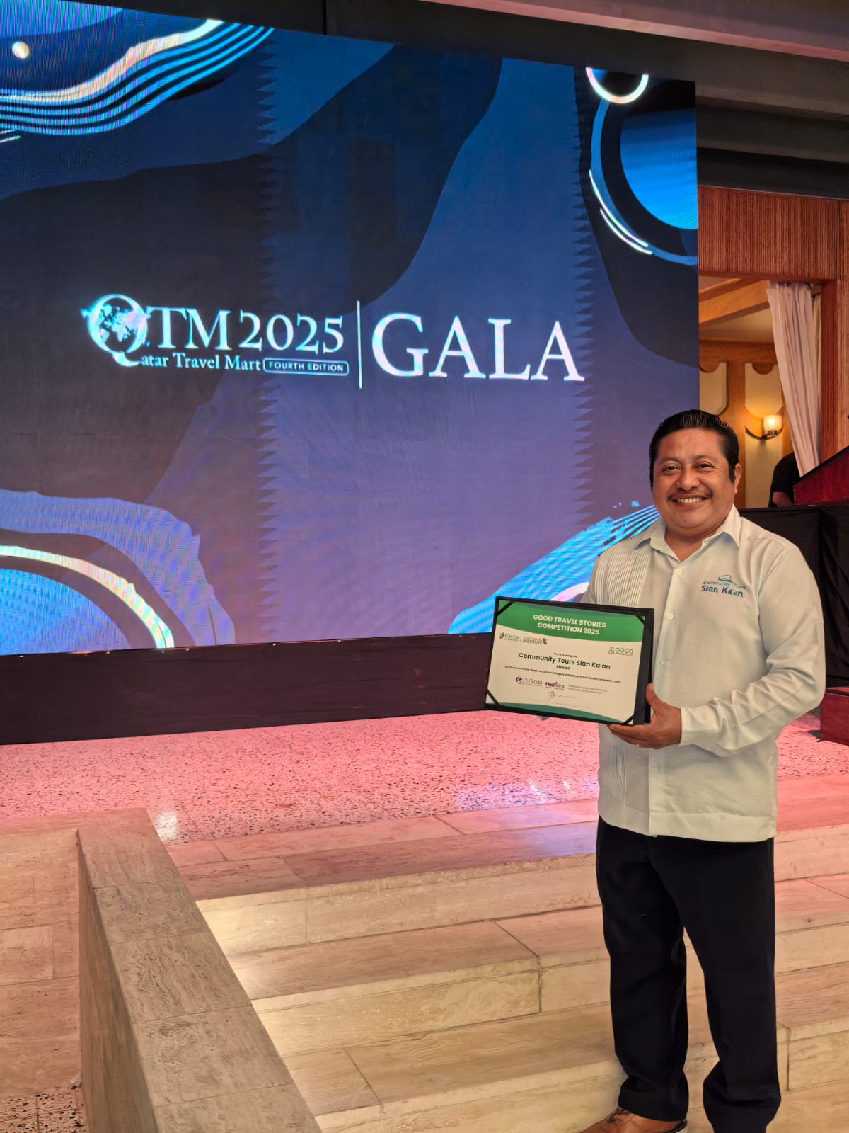 Roman Caamal holding the award at Qatar Travel Mart