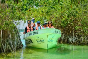 Visitors in life vests on a Community Tours Sian Ka´an boat gliding through a mangrove channel
