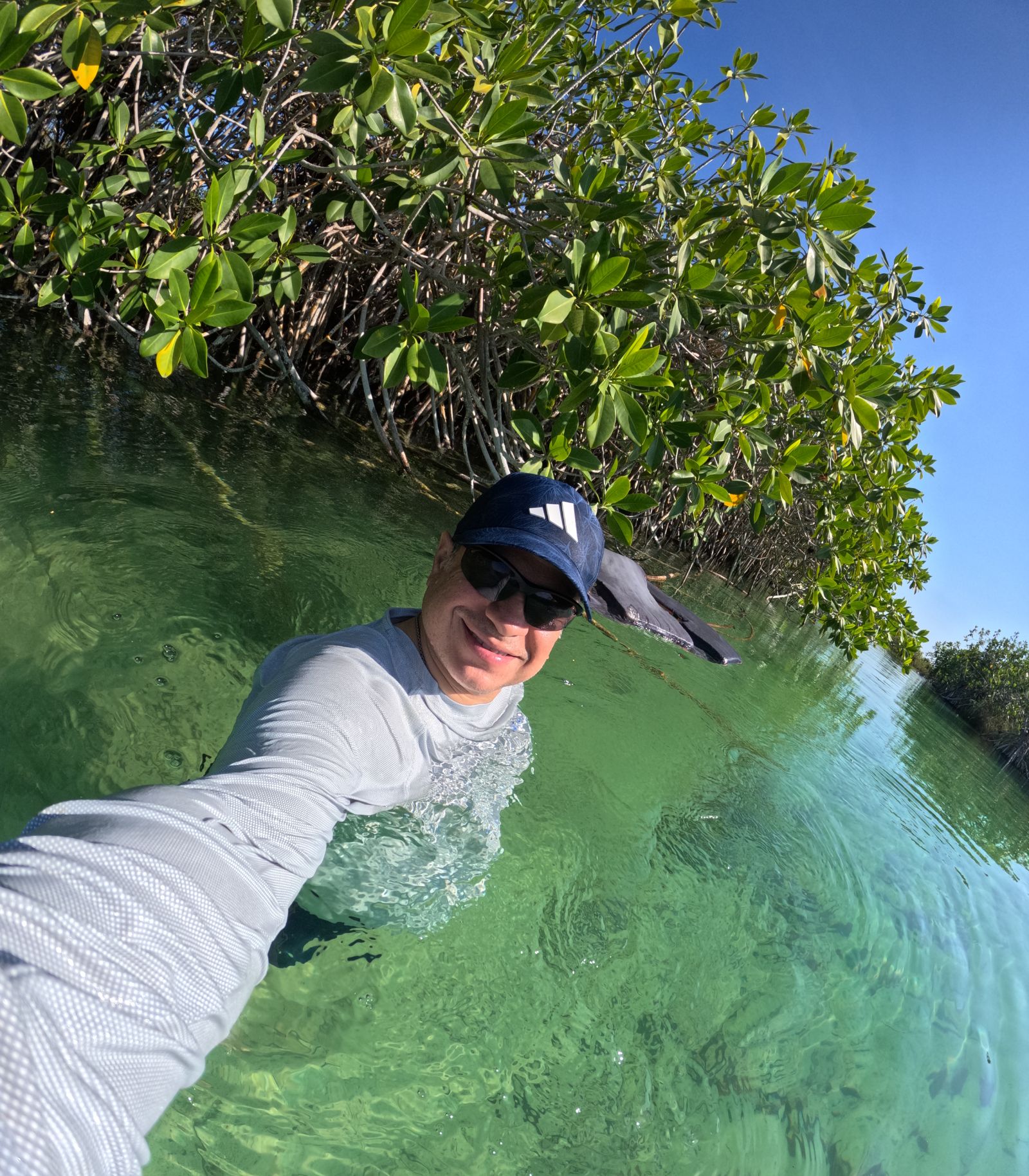 Visitor with life vest floating in the fresh green water of the ancient Maya canal in Sian Ka an