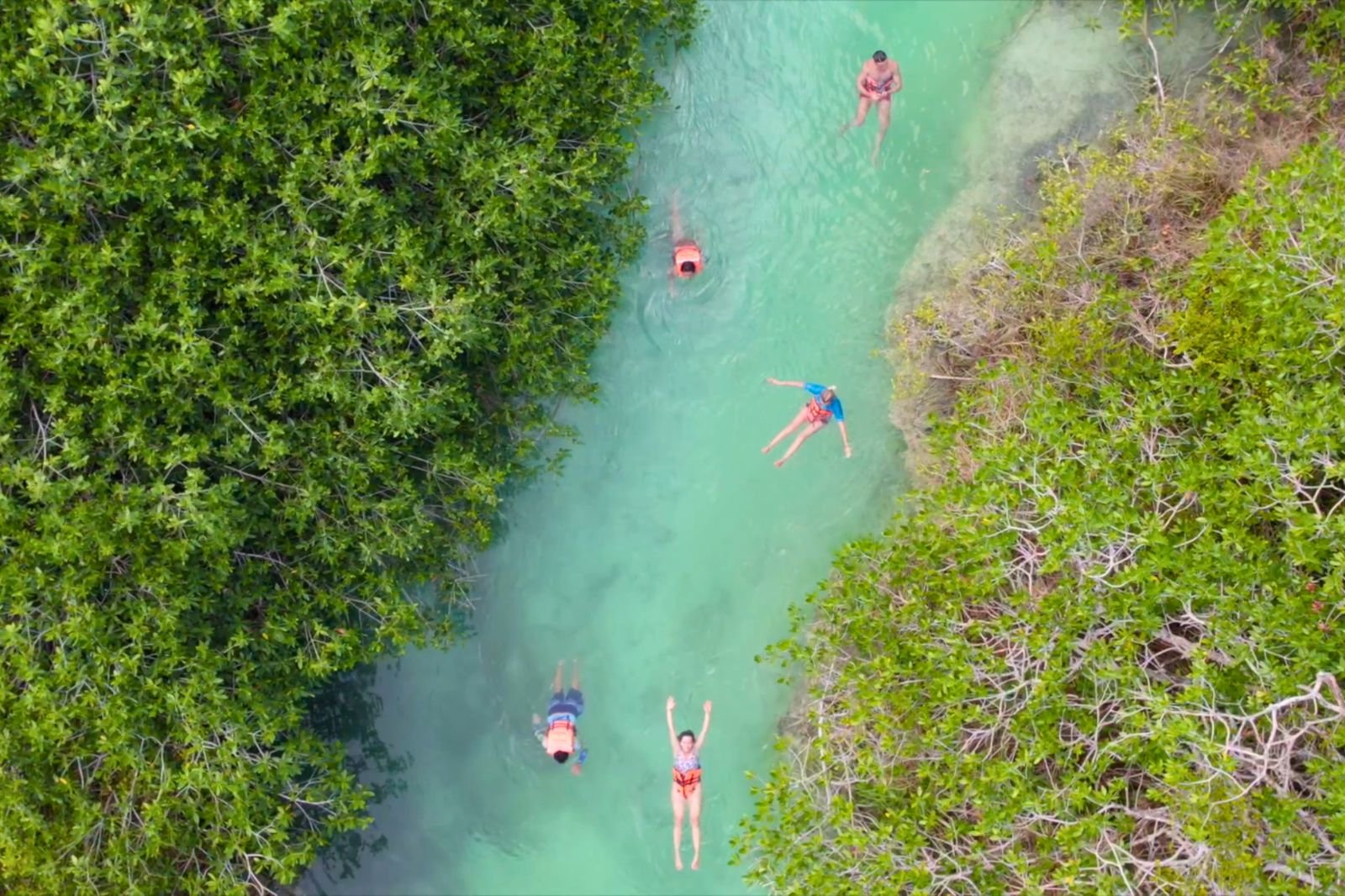 Aerial view of visitors floating single file down the turquoise ancient canal in Sian Ka an
