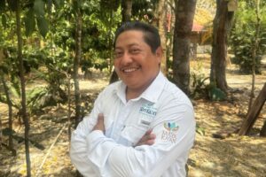 Smiling Maya guide of Community Tours Sian Ka´an standing among trees at the cooperative base