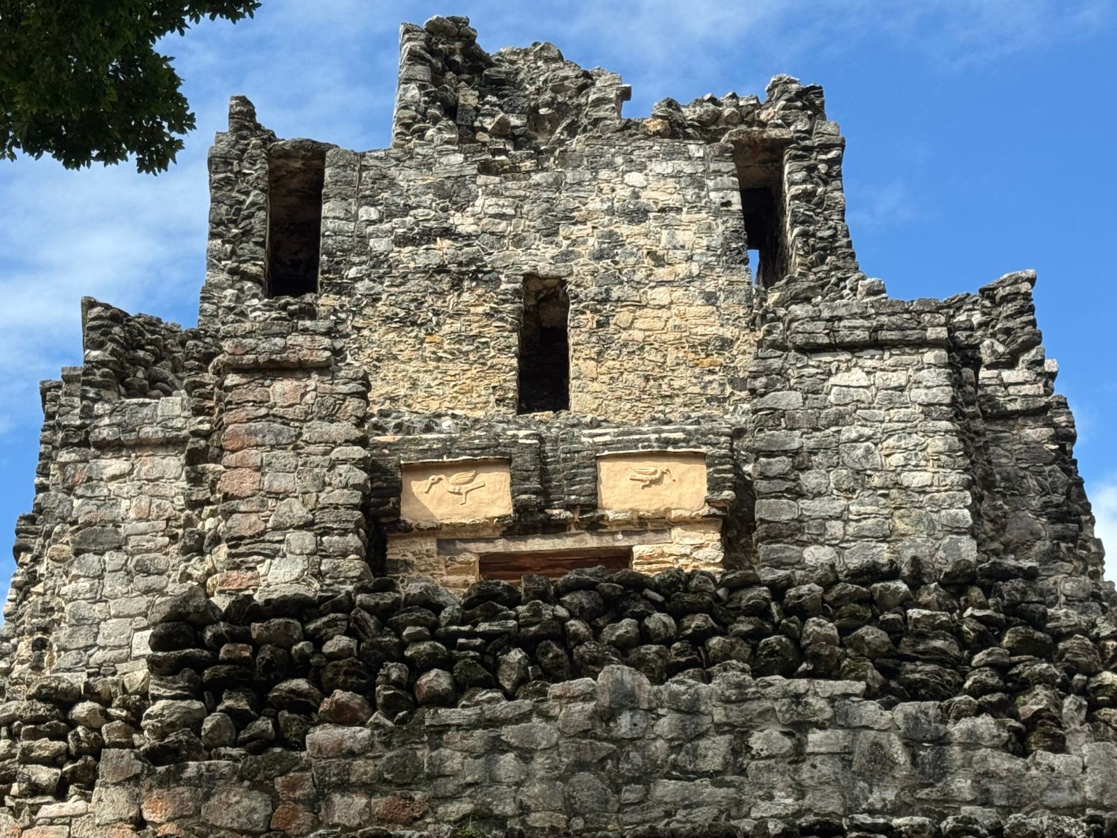 Close-up of the two stucco cormorant figures on the rear facade of El Castillo at the Muyil ruins