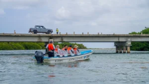 Boat with visitors passing under the Boca Paila bridge where lagoon meets sea