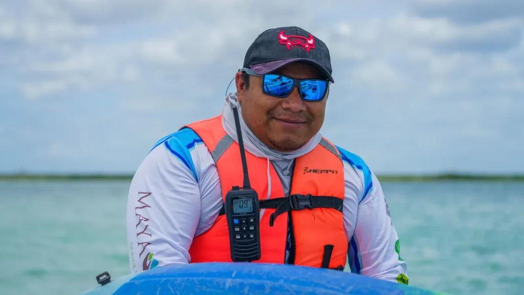 Captain in a life vest and sunglasses at the helm on the lagoon