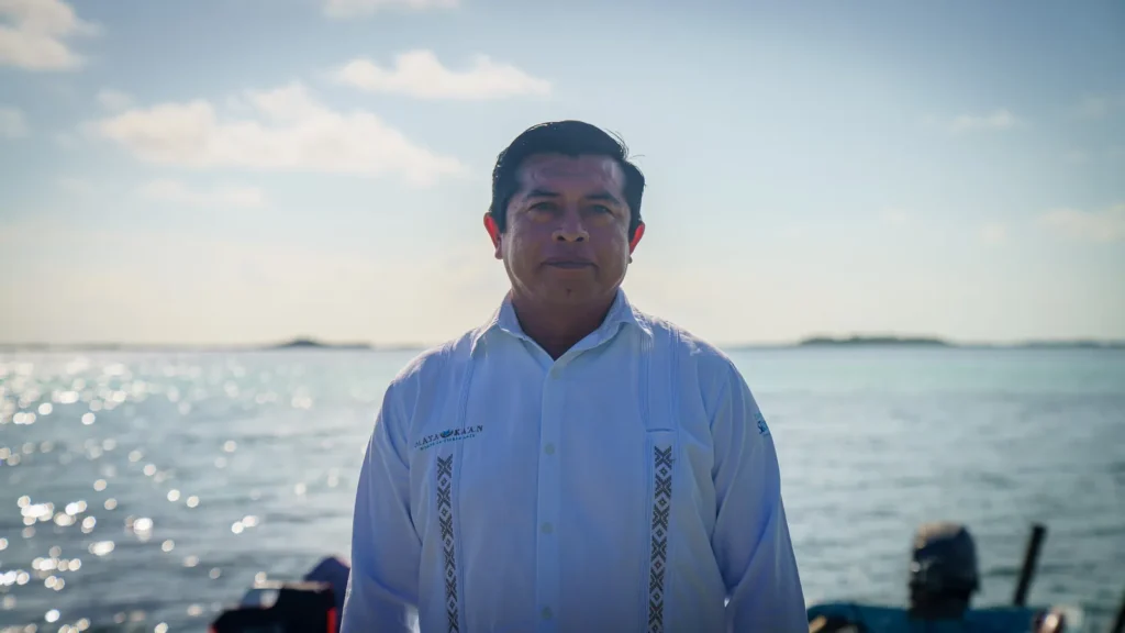 Member of the Maya cooperative in a white guayabera on the Muyil lagoon dock
