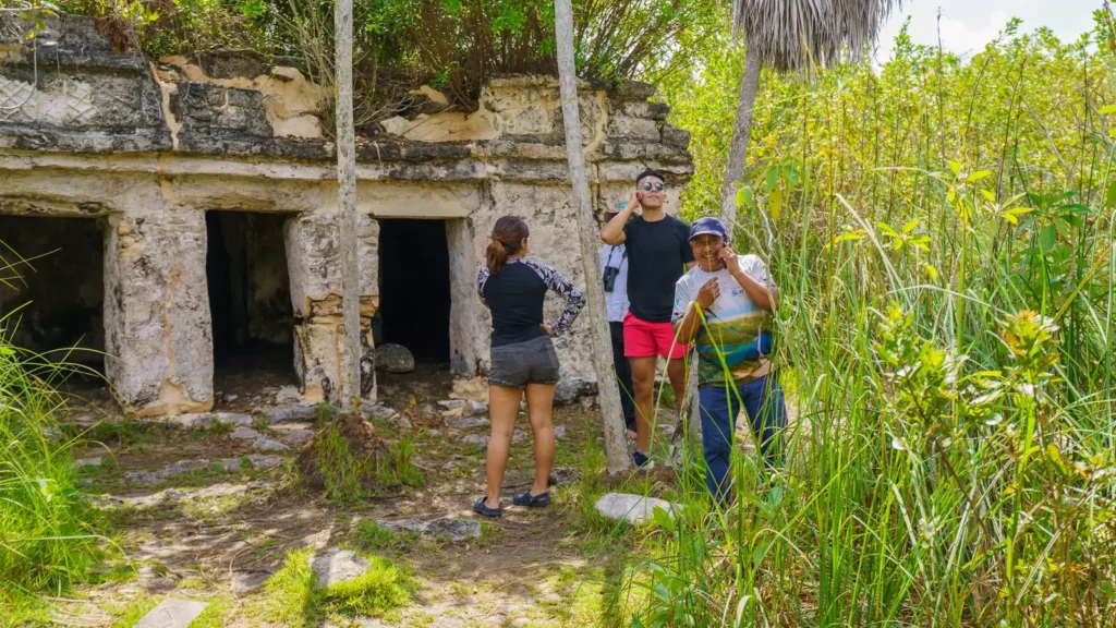 Visitors standing in front of the small Maya temple of Xlapak in the reserve